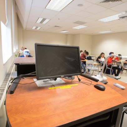 Lectern with monitor students in the background