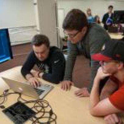 Image of teacher helping students at table