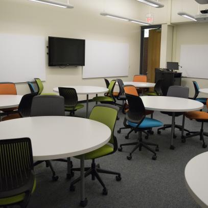 Round tables with display and whiteboards on the wall