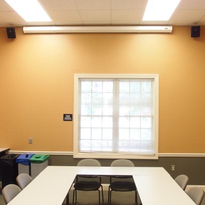 U shaped table with projection screen and speakers mounted on the wall