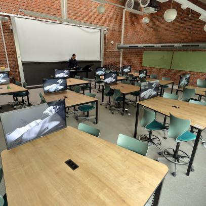 Bar height tables with chairs on wheels and displays at each table